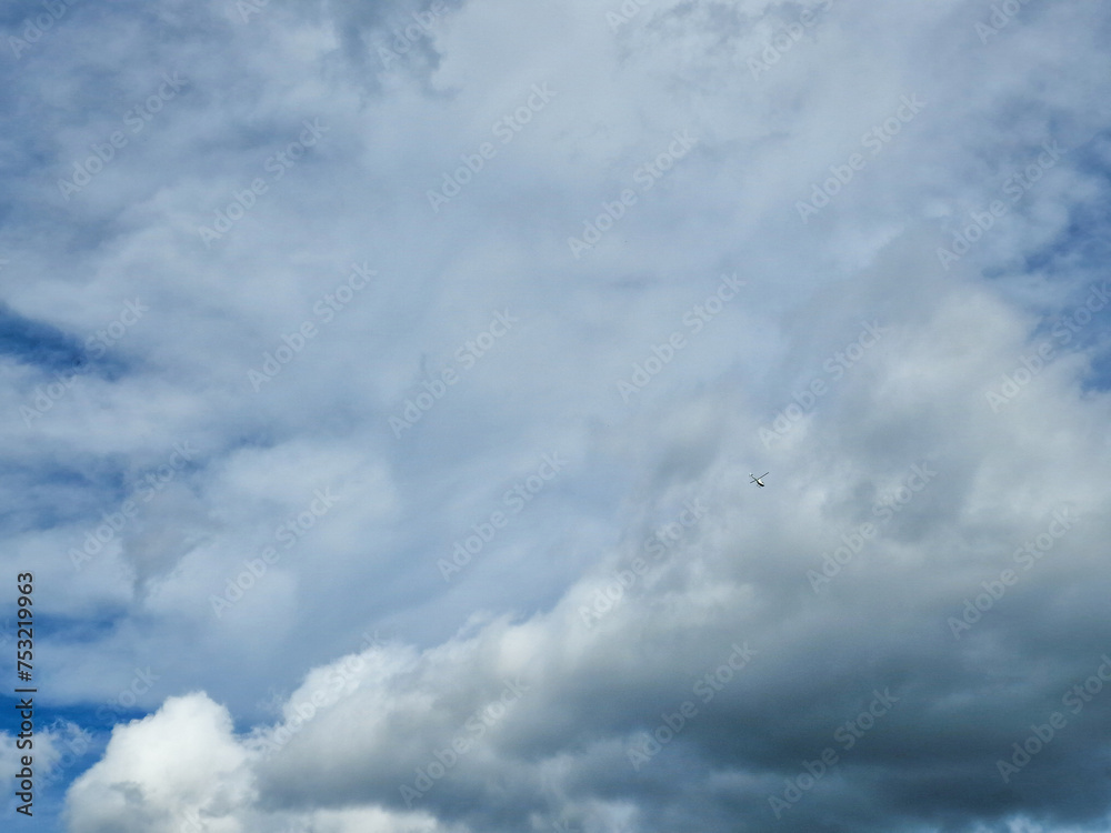 Helicopter against the background of a white clouds. Bottom view on high flying helicopter