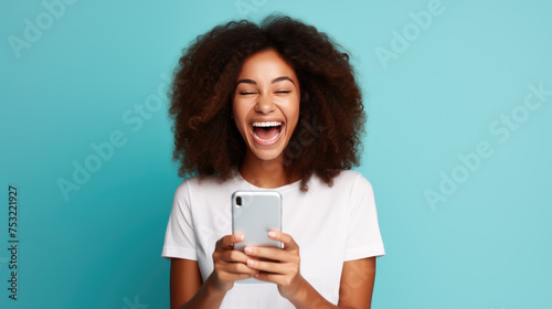 Young girl smiling holding a smartphone on a blue background