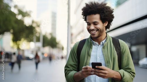 Woman is looking at his smartphone, standing on an urban sidewalk with buildings in the background.