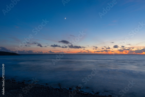 Pose longue au coucher de soleil, capturant la majesté de la mer d'Iroise depuis une plage de la presqu'île de Crozon en Bretagne.