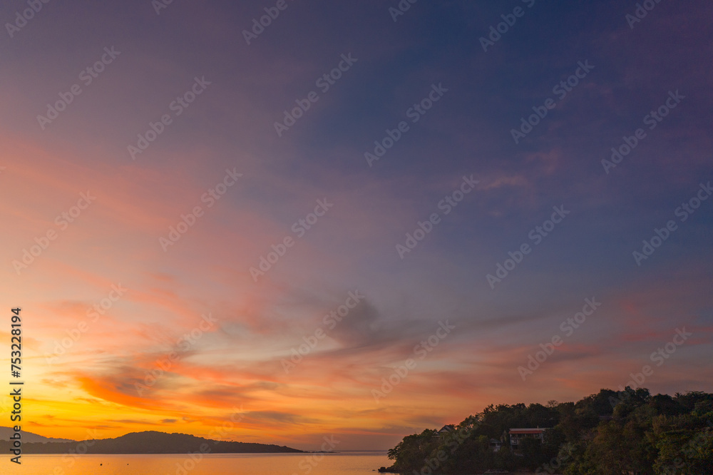 aerial view scenery yellow sky over the island at sunrise..beautiful sky of sunrise at Rawai beach Phuket Thailand.image for travel concept. cloud in sky background..