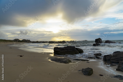 Sur la côte bretonne du Finistère nord, un coucher de soleil hivernal se dévoile en nuances pastel, enveloppant la plage d'une douce lumière photo