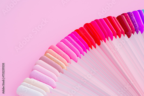 Assorted Nail Polish Samples Fanned Out on Vibrant Pink Backdrop