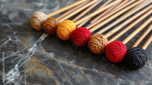 a group of knitting needles sitting next to each other on top of a piece of black and white marbled paper. photo