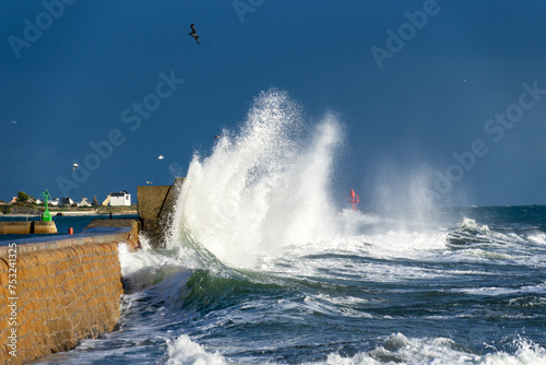 Pendant la grande marée, les vagues colossales se fracassent contre la jetée de Lesconil, dans le Finistère en Bretagne, révélant la majesté et la puissance de l'océan en furie.