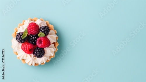 a close up of a pie with berries on top of it on a blue background with a green border around it.