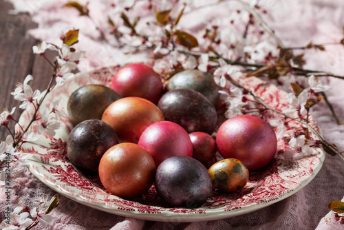 Eggs painted in different colors and covered with mother-of-pearl, and blossoming plum branches. Easter concept.