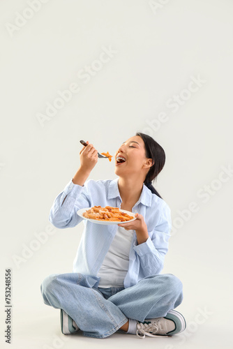 Young Asian woman eating ta...