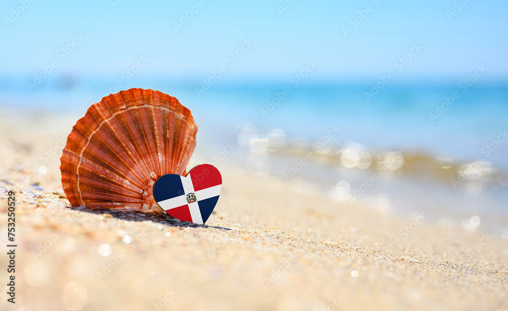 Obraz premium Sandy beach in Dominican Republic. Dominican Republic flag in the shape of a heart and a large shell. A wonderful resort on the Caribbean Sea