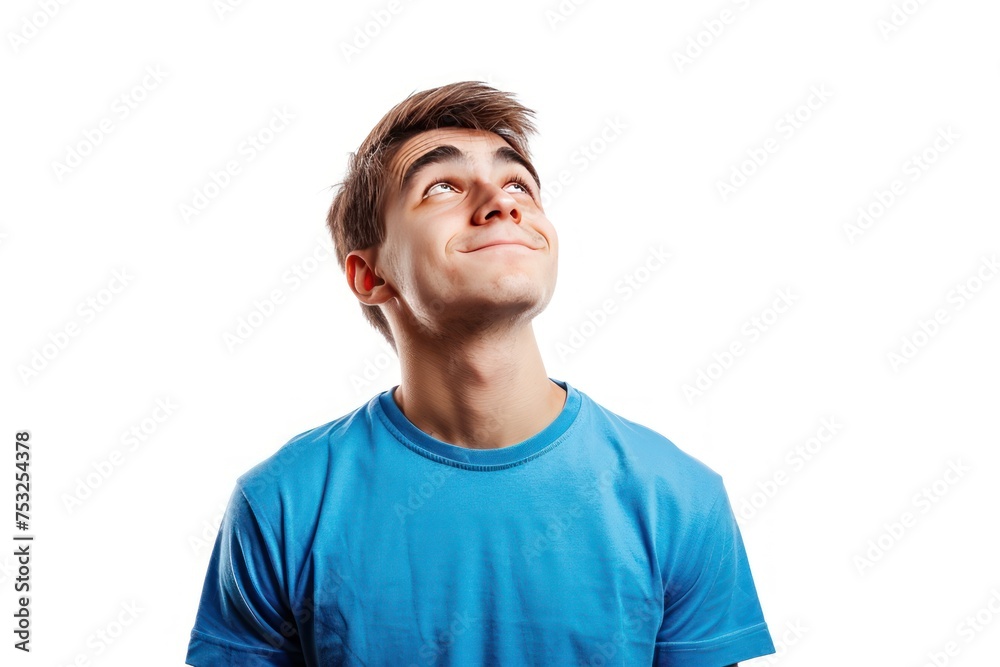 A young man is wearing a blue shirt and looking up at the sky. He has a smile on his face, and his eyes are wide open. Concept of wonder and curiosity