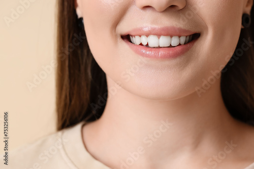 Beautiful woman smiling on beige background, closeup