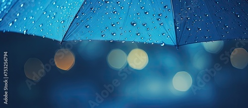 Vibrant Blue Umbrella Shielding from Raindrops in Urban Setting photo