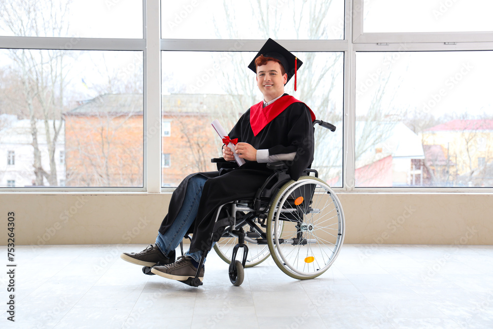 Male graduate in wheelchair with diploma at university hall Male graduate in wheelchair with diploma at university hall