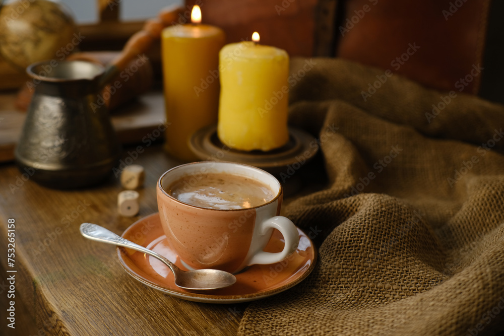 cup with drink coffee on old vintage wooden table, metal coffee maker, candles burn, caffeine improves functioning of human brain, stimulates nervous system, health benefits and harms, copy space