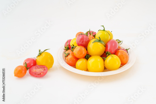 Fresh small persimmons of various colors on white background