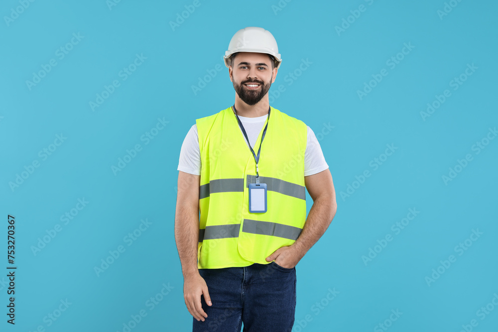 Engineer with hard hat and badge on light blue background