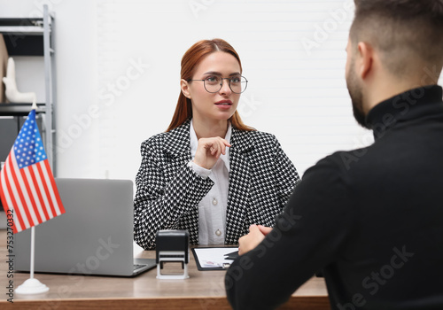 Embassy worker consulting man about immigration to United States of America in office