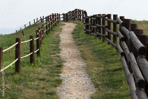 View of the footpath with wooden fence on the hill