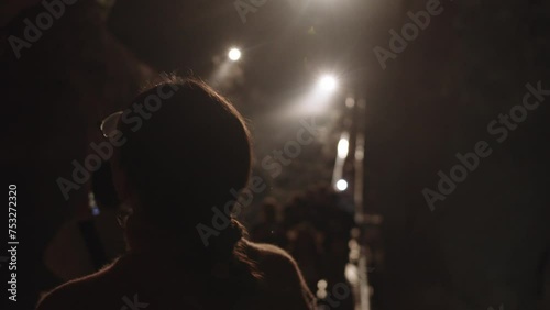 Girl with glasses as part of a tour group inspects a cave