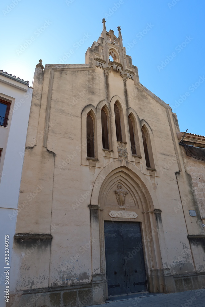 Villena, Alicante, Spain, March 5, 2024: Door, windows and bell tower of a church in the Plaza de las Malvas in Villena, Alicante, Spain