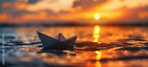 toy paper boat in the water during sunset