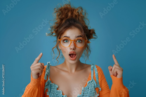 Portrait of nice astonished person open mouth direct fingers up empty space proposition isolated on blue color background photo