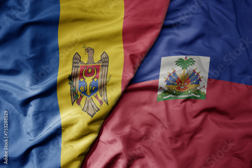 big waving national colorful flag of haiti and national flag of moldova .