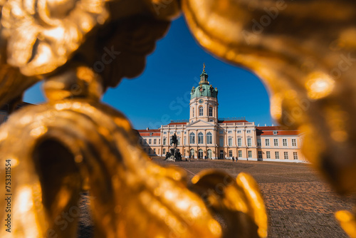 Castle of charlottenburg in Berlin, viewed from the south side. Blue skies on sunny day in spring. Looking through the entrance fence.