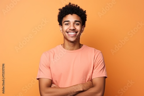 Portrait of a smiling young african american man on orange background © Iigo