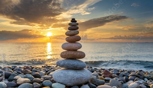 Turret of pebbles on the background of the sunset over the sea