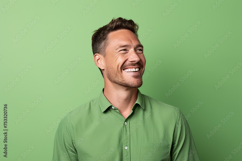 Portrait of a handsome smiling man in green shirt over green background Portrait of a handsome smiling man in green shirt over green background