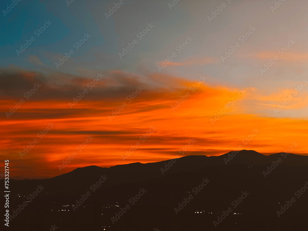 Fototapeta premium Beautiful sunset with orange sky and huge cloud seen from the Manrique neighborhood. Medellin, Antioquia, Colombia.