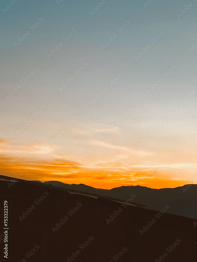 Fototapeta premium Beautiful sunset with orange sky and huge cloud seen from the Manrique neighborhood. Medellin, Antioquia, Colombia.