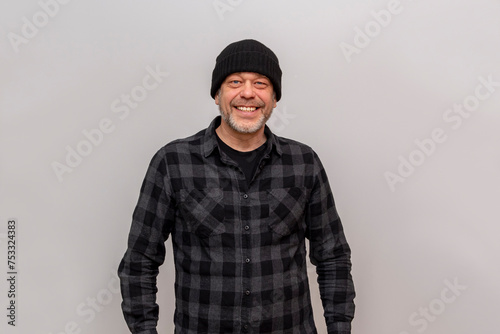 Happy man 45-50 years old in a black hat standing on a white background