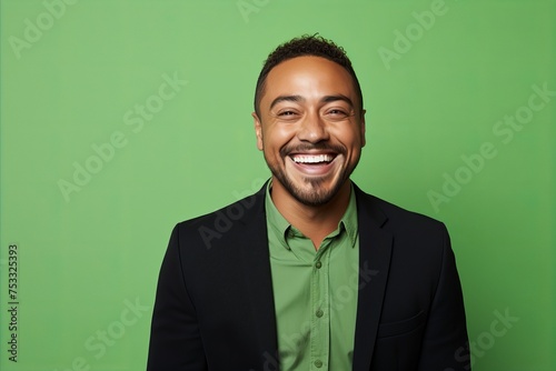 Portrait of happy african american man in black suit on green background