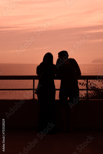  sunset with a couple looking at the sea and showing off their sweet and blossoming love on the beaches of Peru Lima