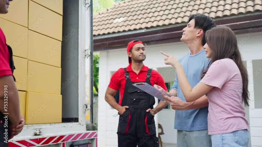 Couple young man and woman check the product in truck that transfer by delivery workers in front of their house for moving to new house.