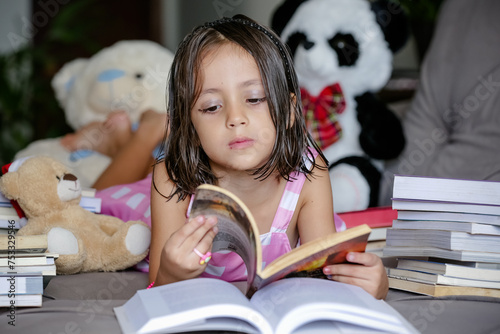 Pausa para Imaginar Criança deitada Entre Contos e Fábulas lendo livros no sofá.