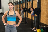 Cheerful girl in sportswear standing and posing in gym