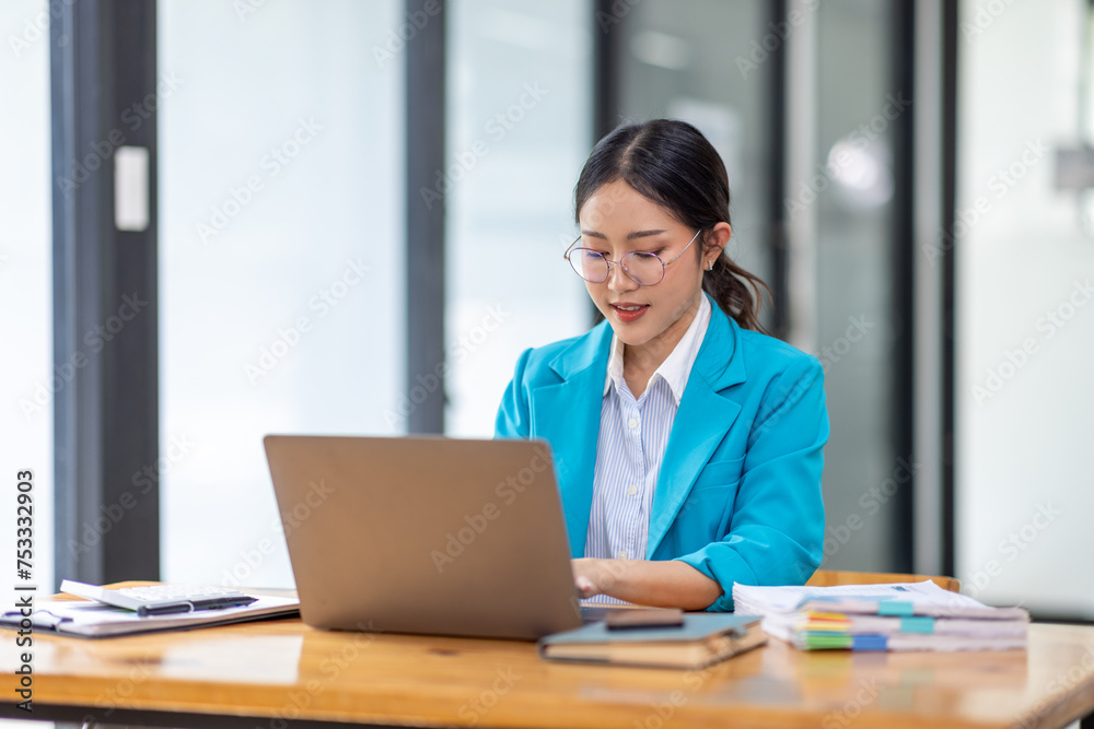 Portrait of asian young female entrepreneur sitting at her desk in the office Portrait of asian young female entrepreneur sitting at her desk in the office