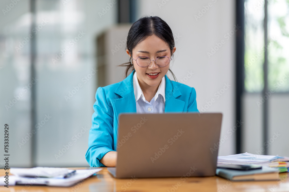 Portrait of asian young female entrepreneur sitting at her desk in the office Portrait of asian young female entrepreneur sitting at her desk in the office