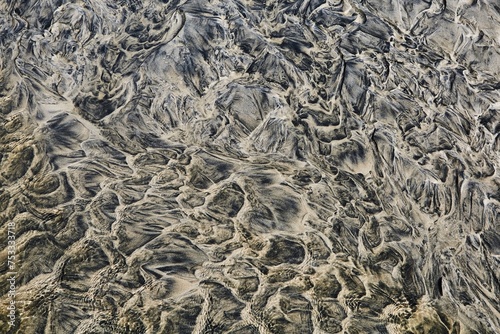 Wet sand and water strange, dark, abstract patterns