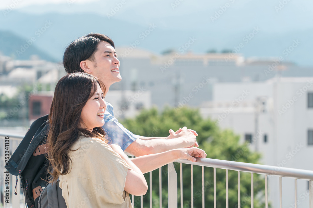屋上で街・景色を眺める学生・大学生の男女カップル
