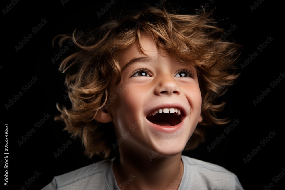 Portrait of a cute little boy with curly hair on a black background Portrait of a cute little boy with curly hair on a black background