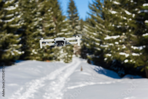 A small drone recording footage in forest.