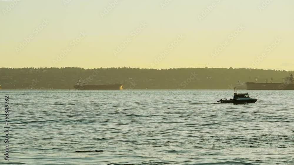 Small motor boat with fisherman heading out to fishing spot on the bay on a hazy summer golden hour Small motor boat with fisherman heading out to fishing spot on the bay on a hazy summer golden hour