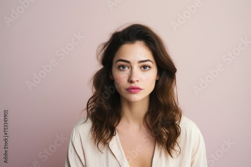 Portrait of a beautiful young woman looking at camera over pink background
