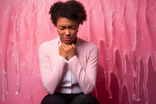 photo of woman in pain in front of pink background, sexual and reproductive health