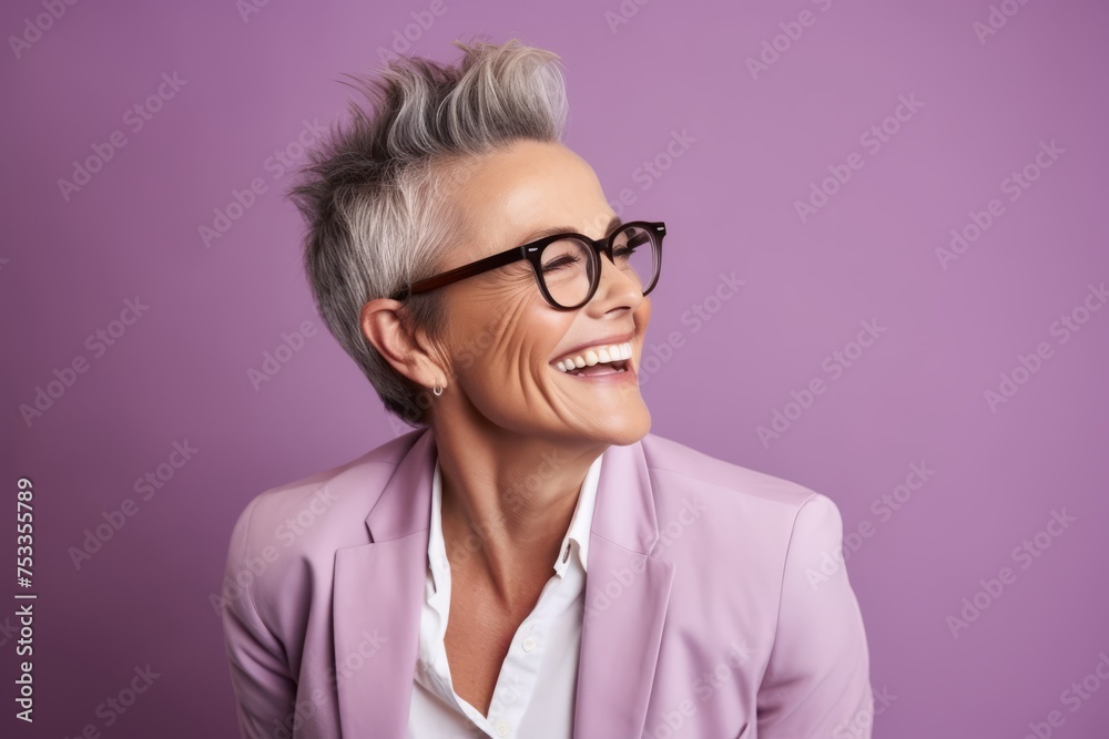 Portrait of smiling mature businesswoman in eyeglasses against violet background