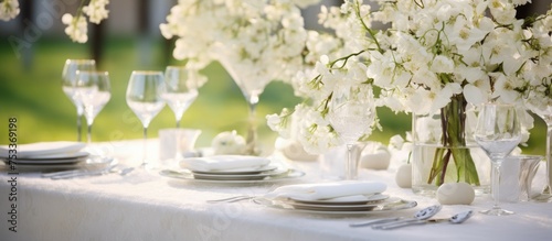 Elegant wedding table decoration with blossoming apple tree flowers special event celebration Fancy white plates and wine glasses